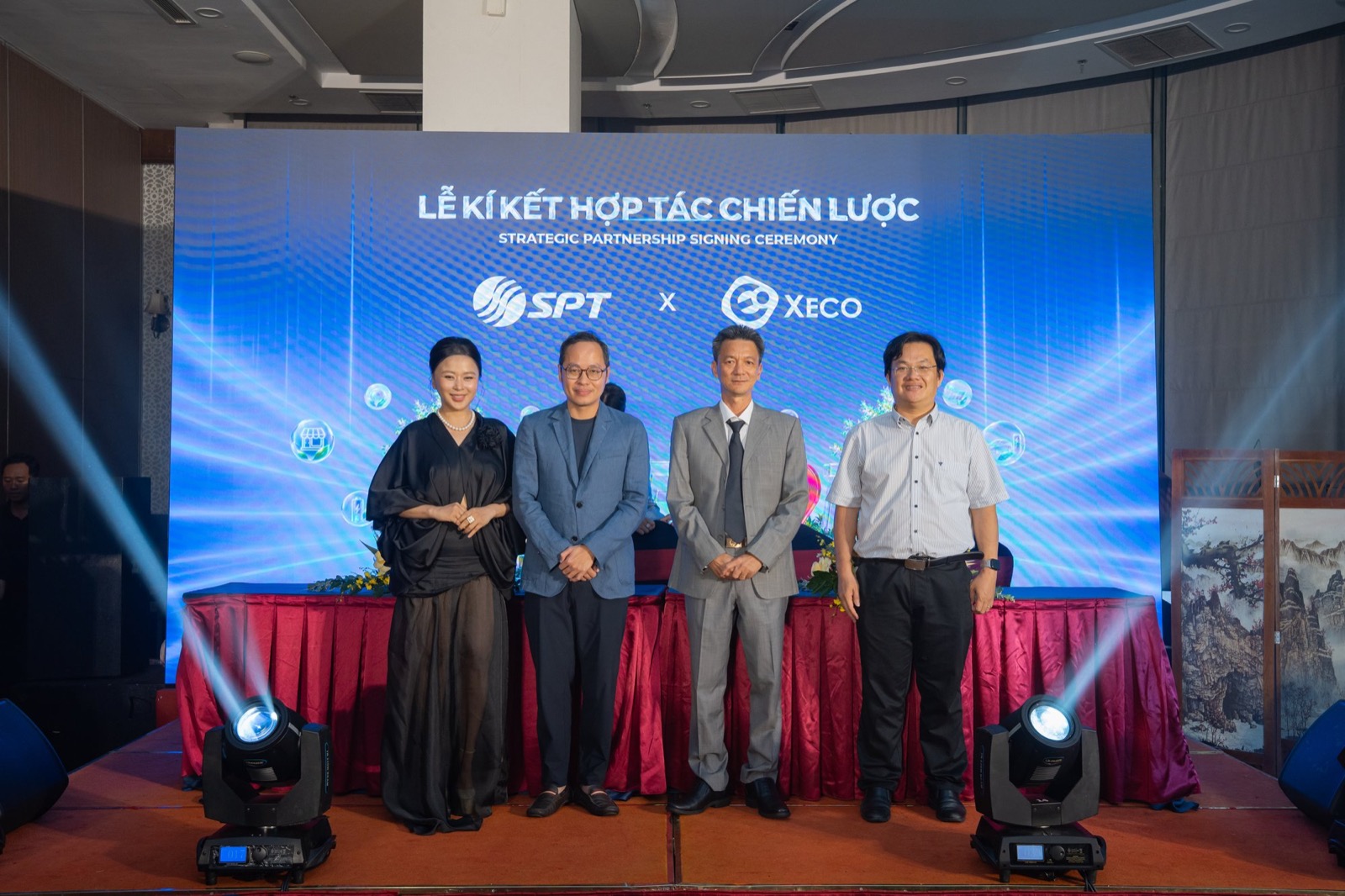 Bốn đại diện đứng trước màn hình LED hiện logo Tập đoàn SPT và XECO sau khi ký biên bản ghi nhớ đợt hai