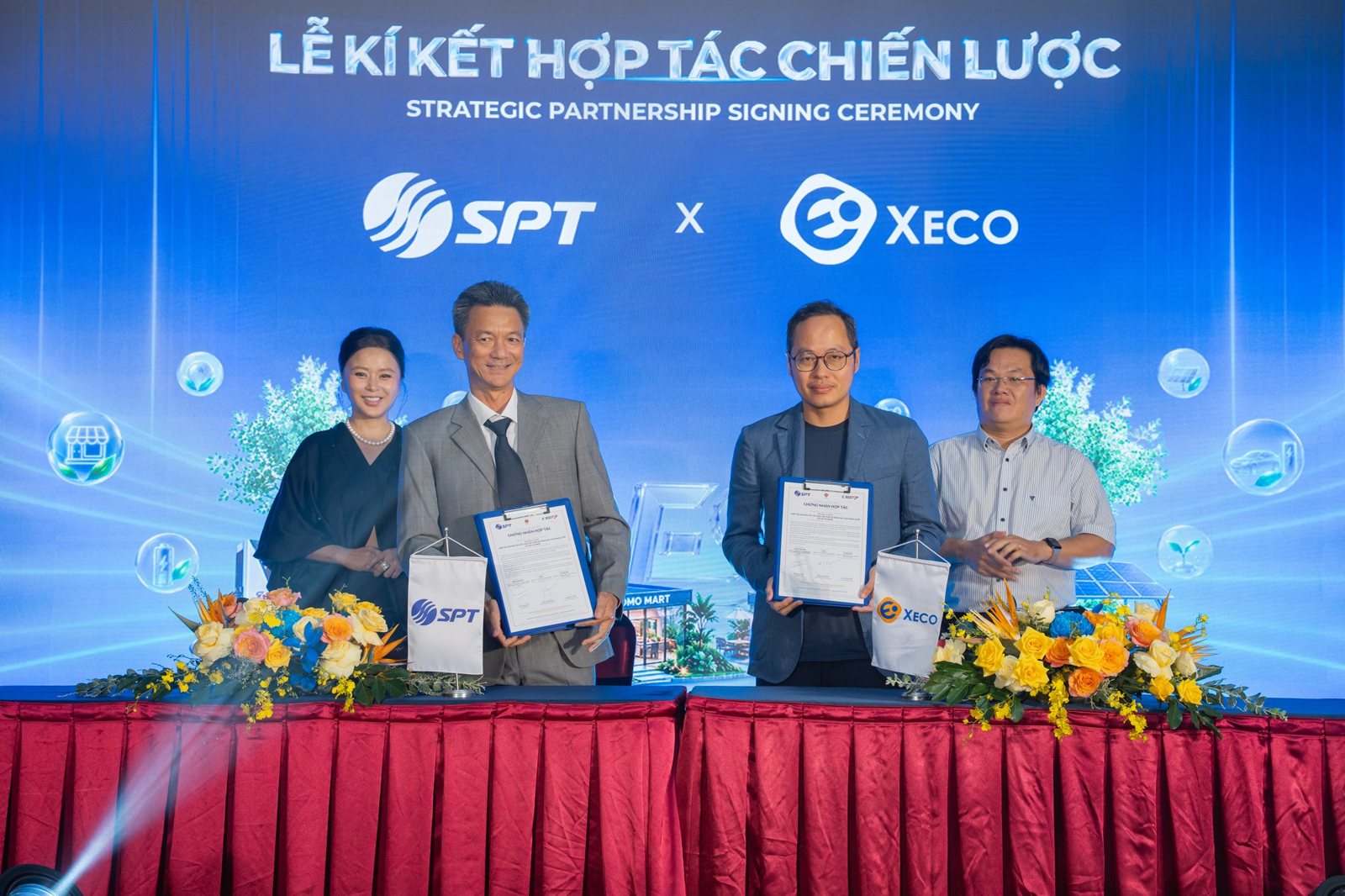 Представители Группы SPT и XECO держат на сцене только что подписанный документ, на LED-экране позади — логотипы SPT и XECO, представитель CD Restop стоит рядом как свидетель